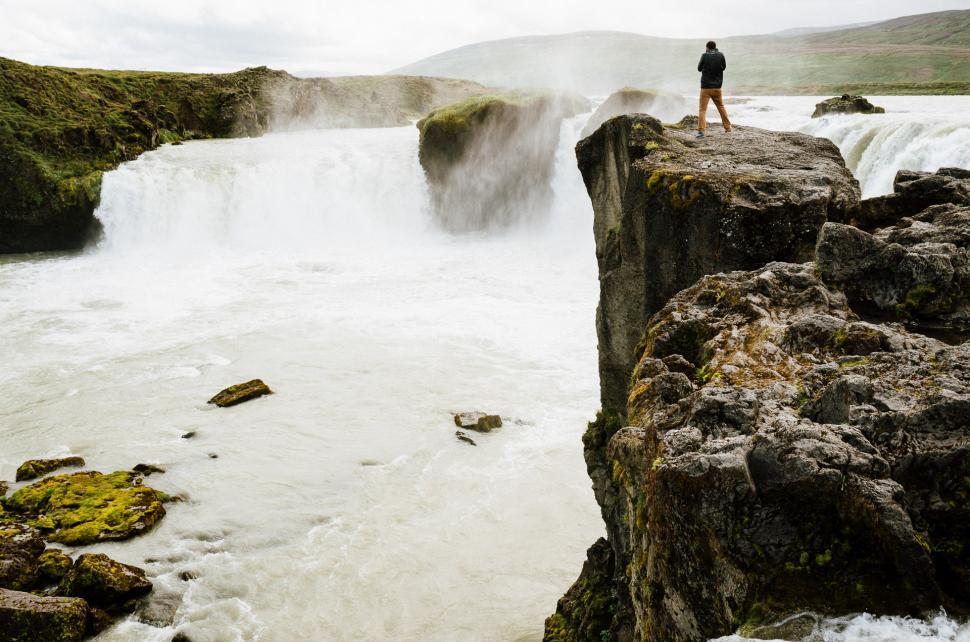 Free Image of Person Standing on Cliff Overlooking Waterfall 