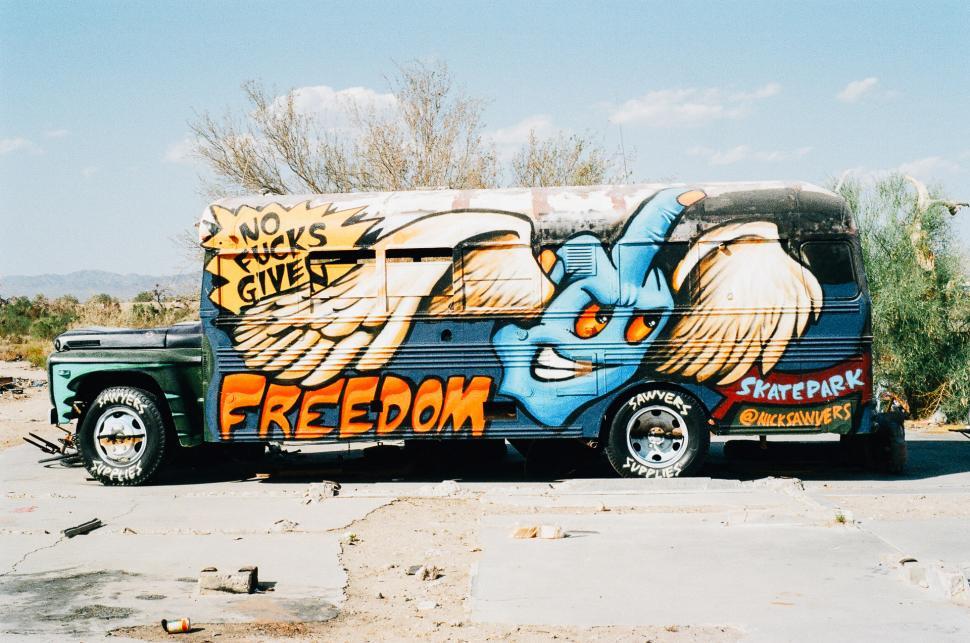 Free Image of Graffiti-Covered Bus in Parking Lot 