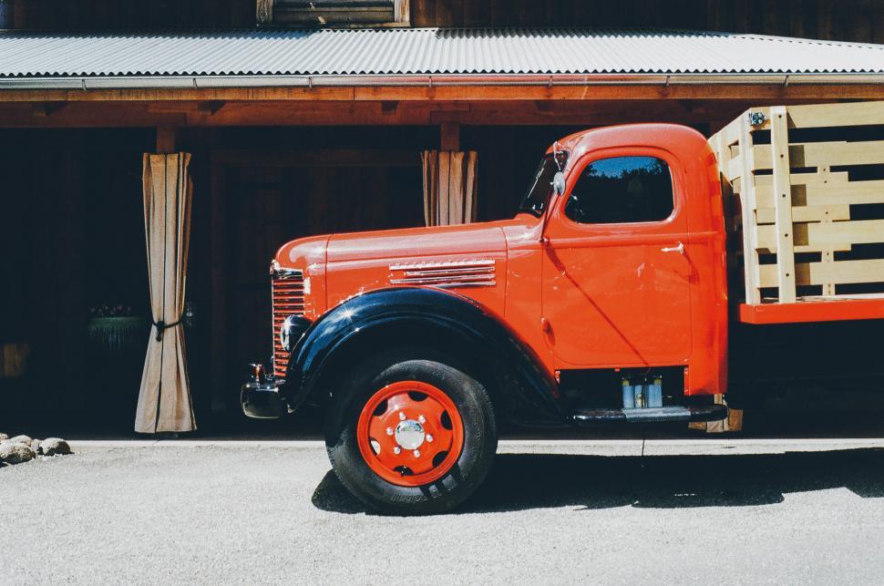 Free Image of Orange Truck Parked in Front of Building 