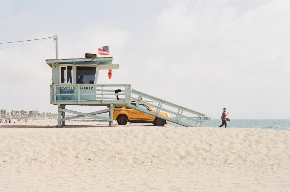 Free Image of Lifeguard Stand on Beach With Parked Car 