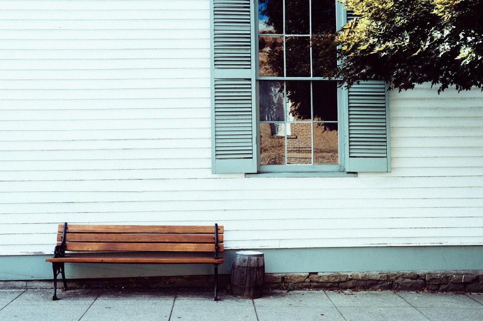 Free Image of Wooden Bench in Front of White Building 