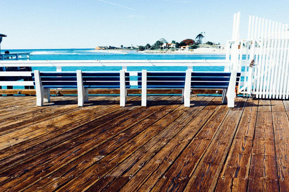 Free Image of Wooden Deck and White Fence by Waterfront 