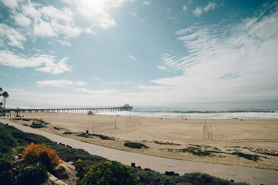 Free Image of Sandy Beach With Pier in Background 