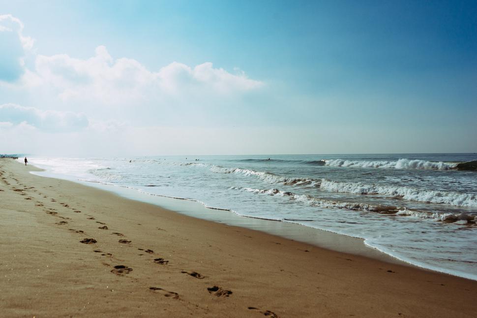 Free Image of Person Walking Along Beach Next to the Ocean 