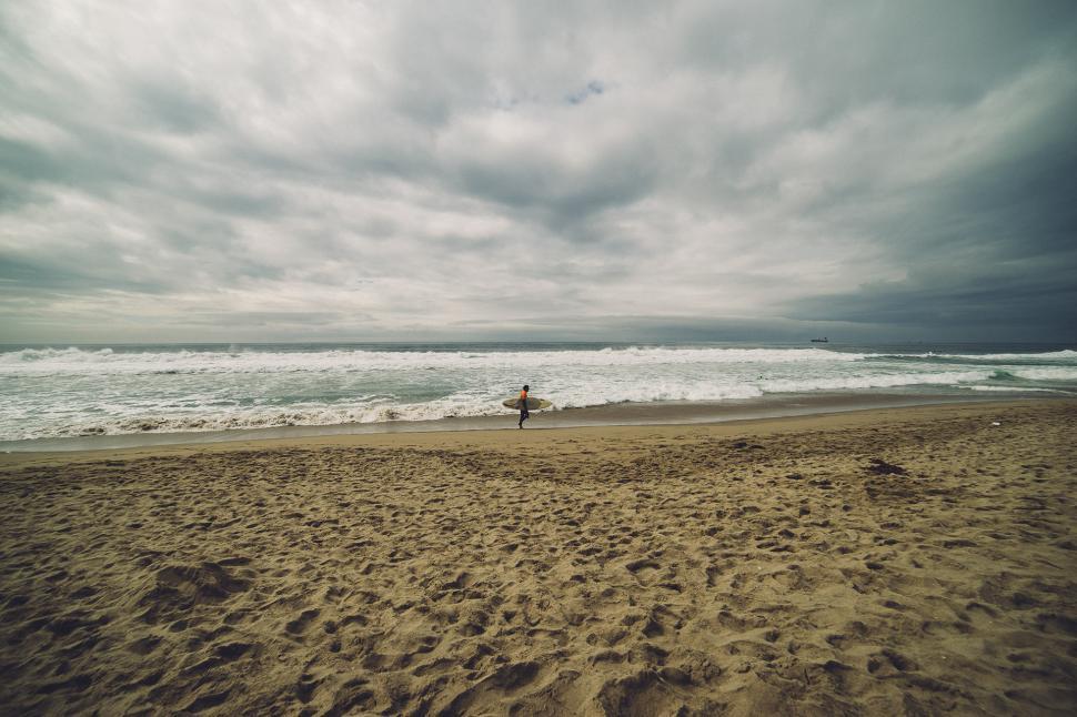 Free Image of Person Standing on Beach With Surfboard 