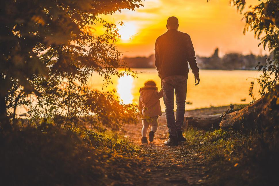 Free Image of Man and Little Girl Walking Down Path 