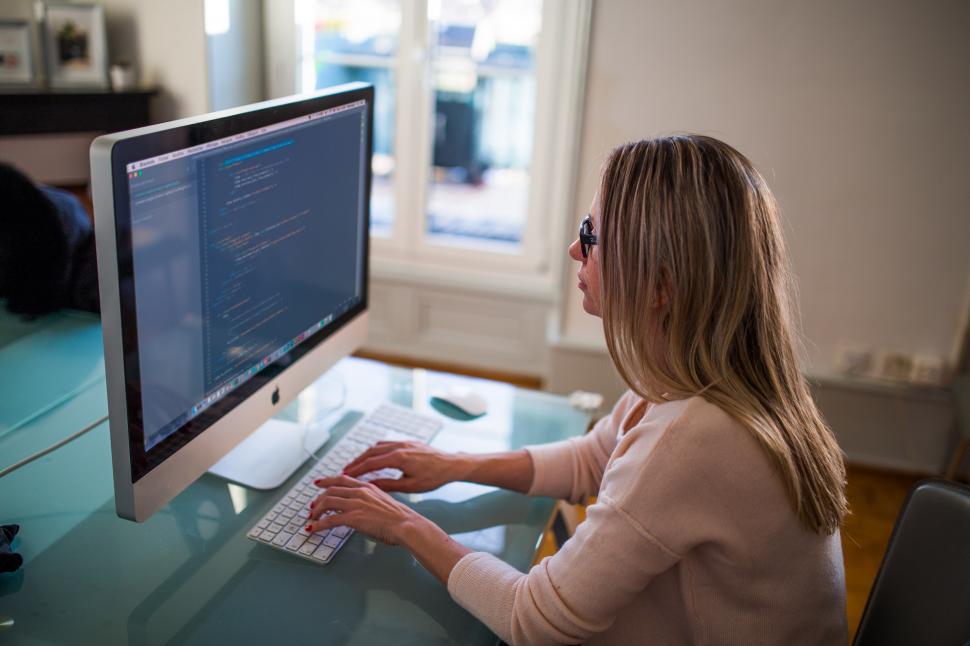 Free Image of Woman Sitting at Desk Using Computer 
