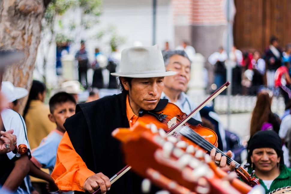 Free Image of Man in a White Hat Playing a Violin 
