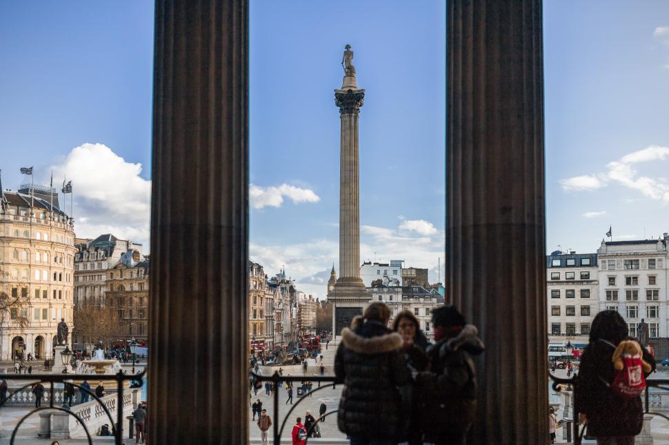 Free Image of Group of People Standing in Front of Tall Pillar 