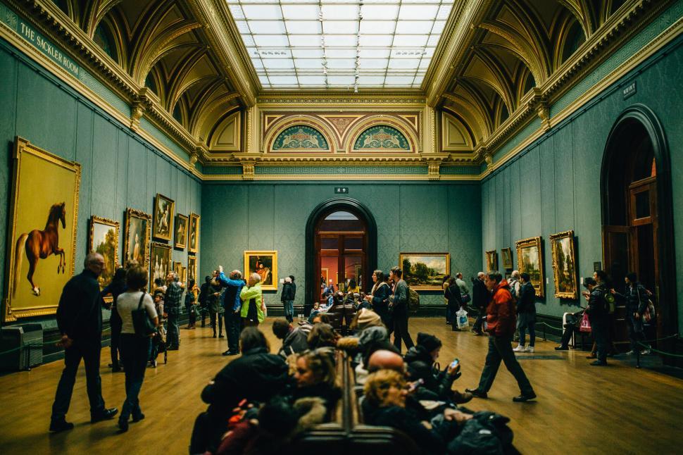 Free Image of Group of People Viewing Paintings in Museum 