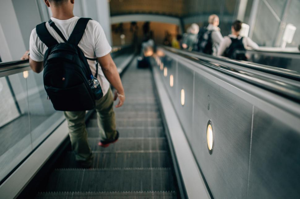 Free Image of Man Descending Escalator With Backpack 