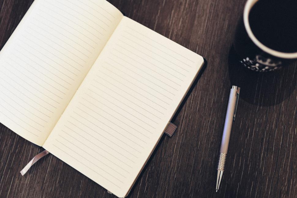 Free Image of A Cup of Coffee and a Notebook on a Table 