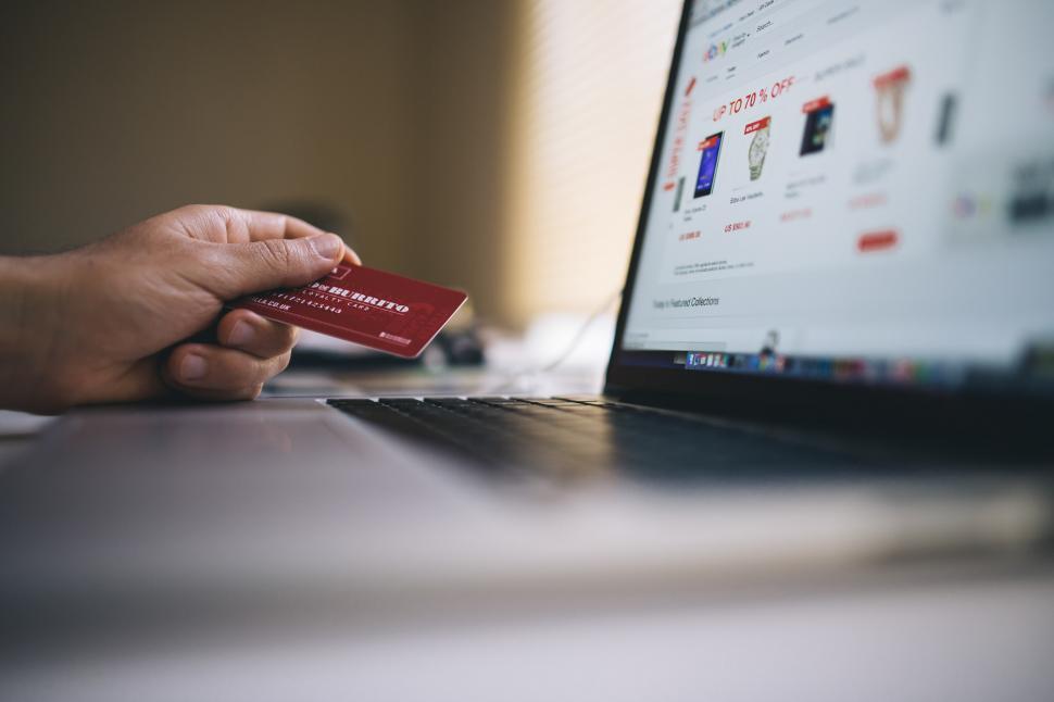 Free Image of Person Holding Credit Card in Front of Laptop 