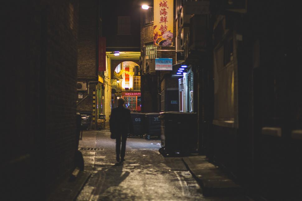 Free Image of Man Walking Down Dark Alleyway at Night 