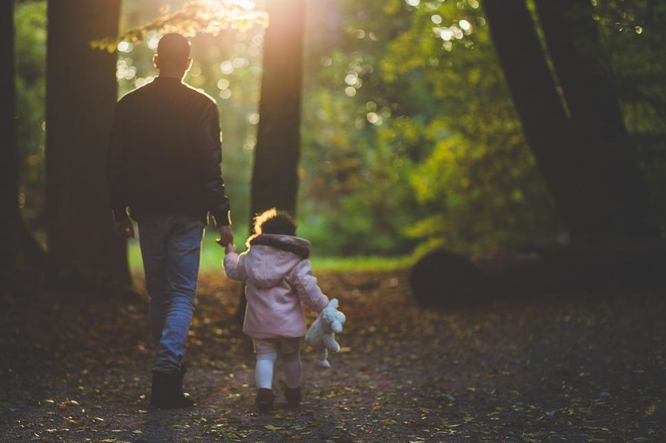 Free Image of Man and Little Girl Walking Through Forest 