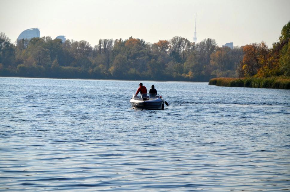 Free Image of Two fishermen on a boat in the middle of the river  