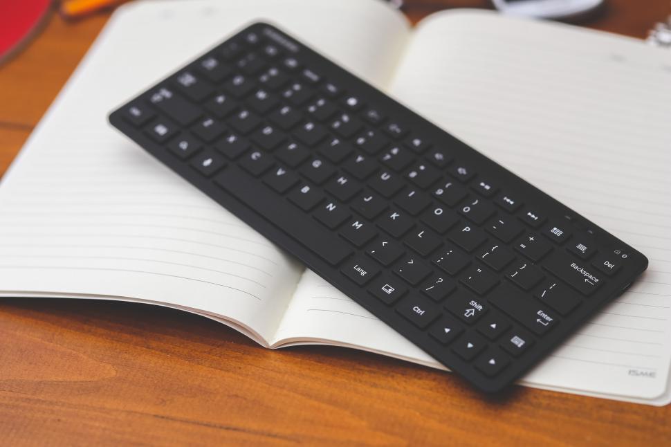 Free Image of Black Keyboard on Open Book 