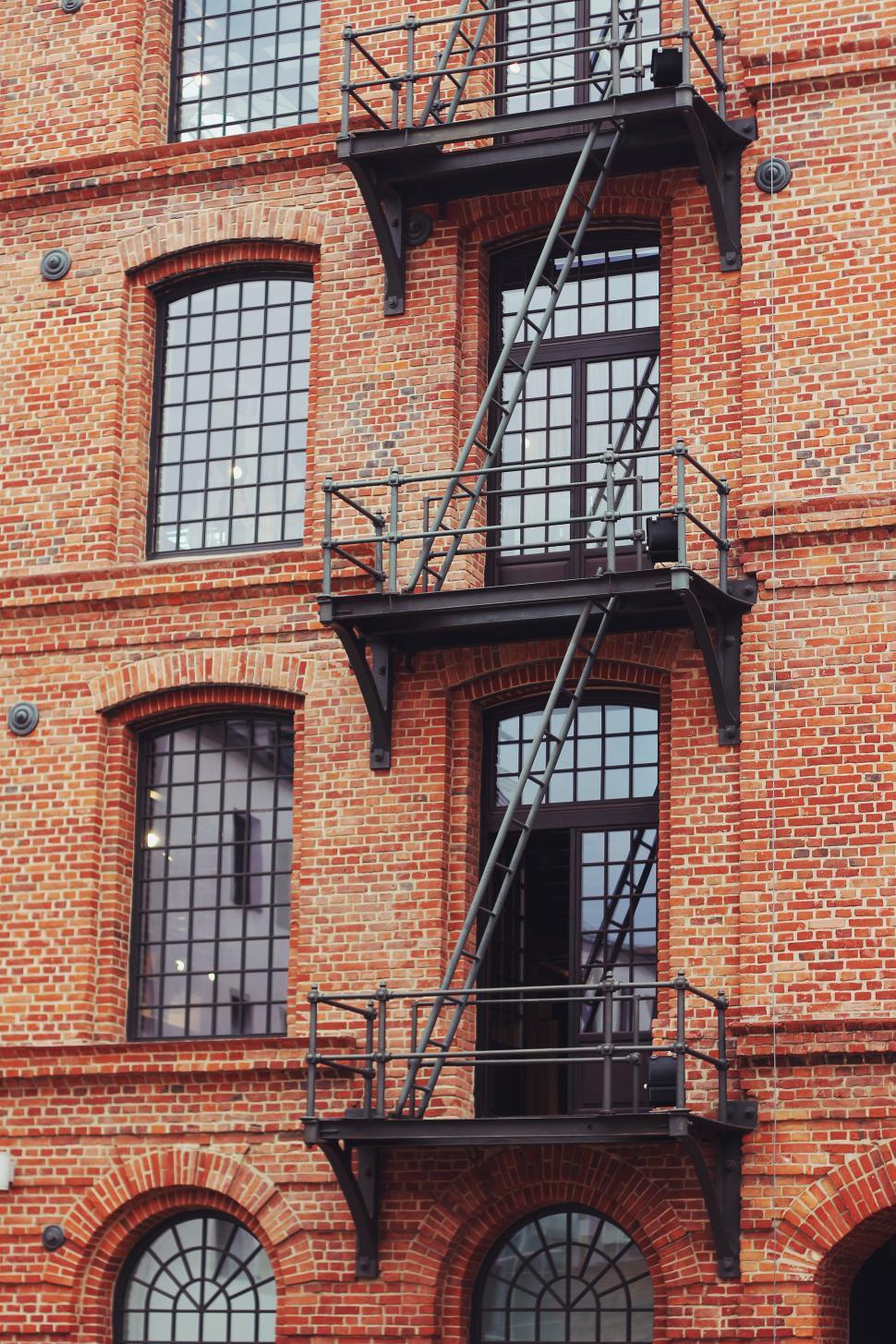 Free Image of Tall Brick Building With Lots of Windows 