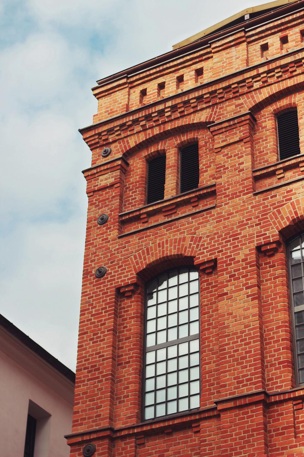Free Image of Tall Brick Building With Clock on Side 
