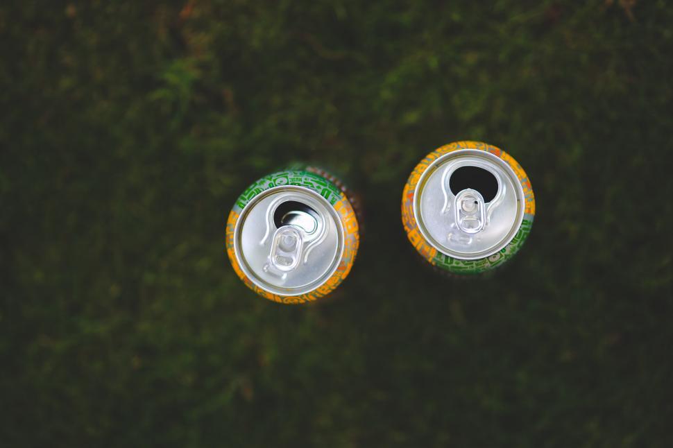 Free Image of Two Cans of Soda on Green Field 
