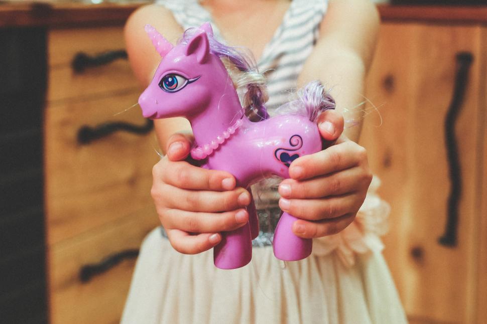 Free Image of Little Girl Holding Pink Toy Horse 