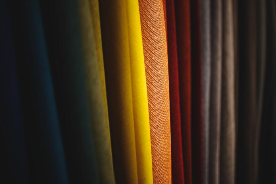 Free Image of Row of Different Colored Curtains Hanging on Wall 