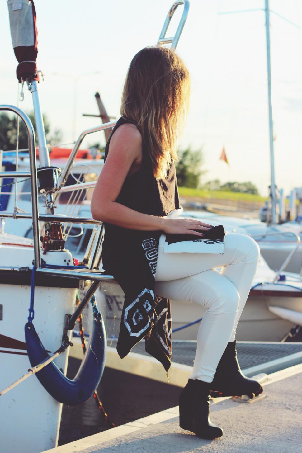 Free Image of Woman Sitting on the Edge of a Boat 