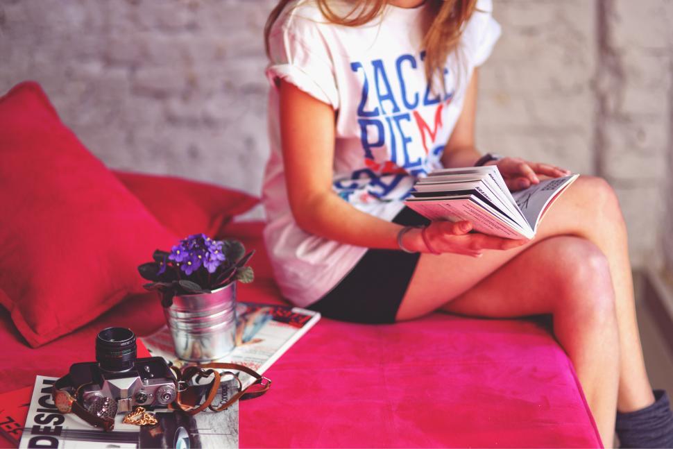 Free Image of Girl Sitting on Bed Reading a Book 
