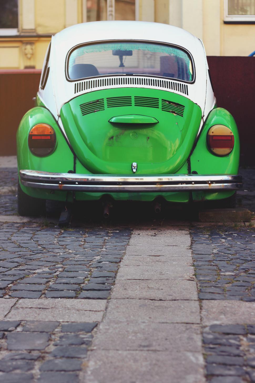 Free Image of Green and White Car Parked on Brick Road 