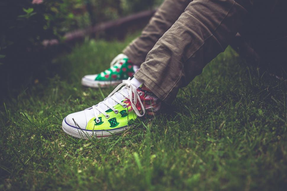 Free Image of Colorful Garden Green Sitting Teenager Young grass handmade laces legs painted shoes sneakers teenage shoe footwear running shoe covering 