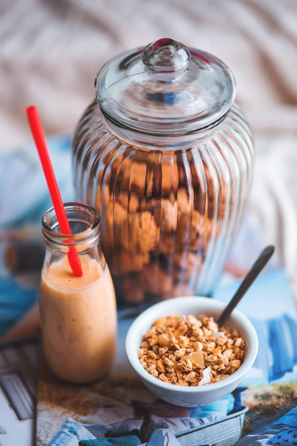 Free Image of Glass Jar Filled With Granola Next to a Bowl 