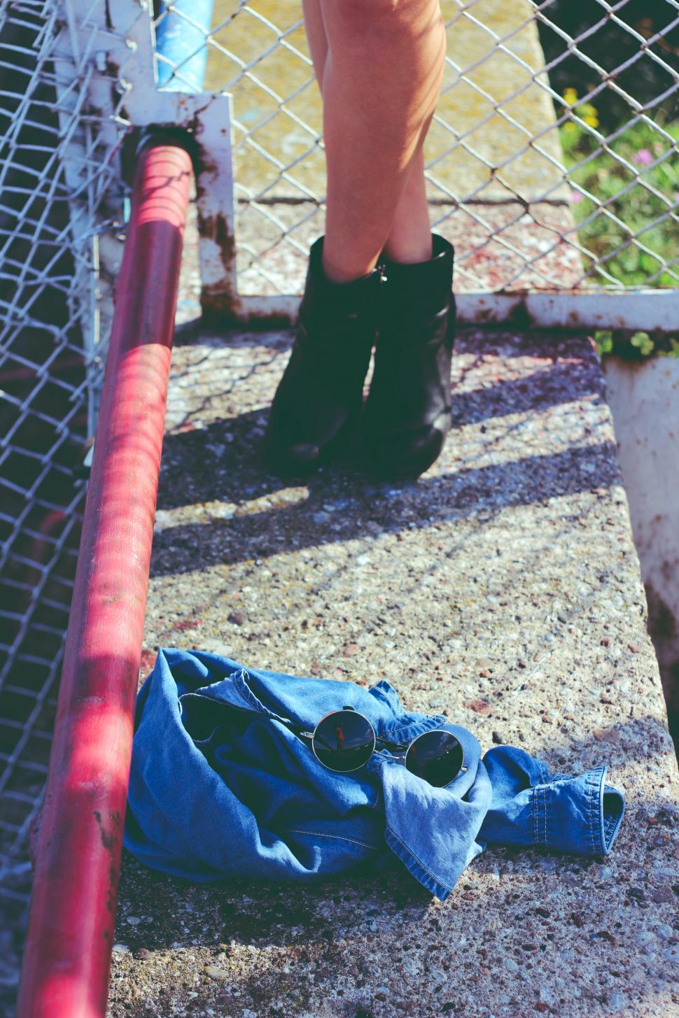 Free Image of Black Boots Resting on Blue Jeans 