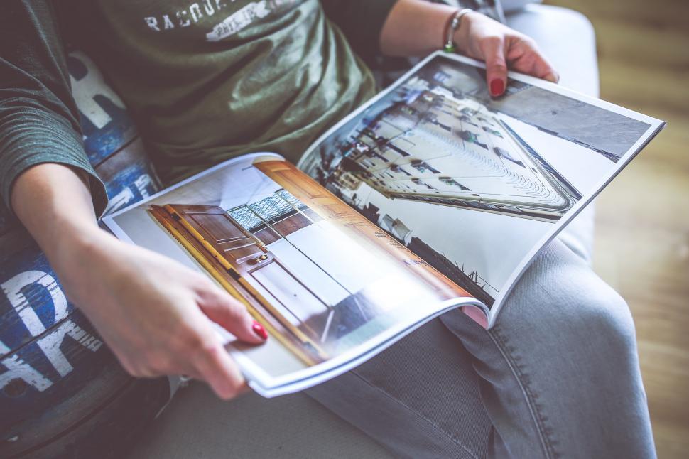 Free Image of Person Sitting on Couch Holding Magazine 