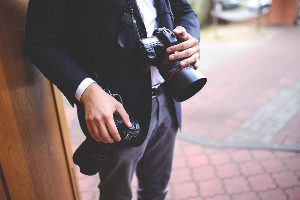 Free Image of Man in Suit Holding Camera 