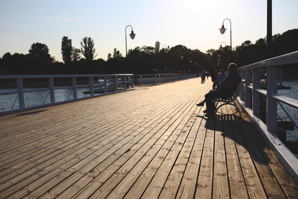 Free Image of Person Sitting on Bench on Pier 