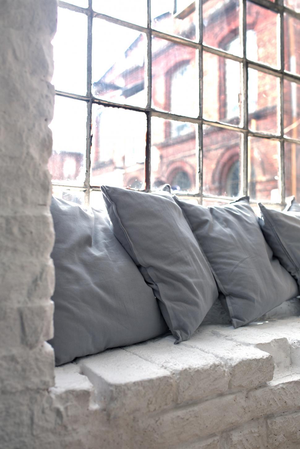 Free Image of Row of Pillows on Window Sill 