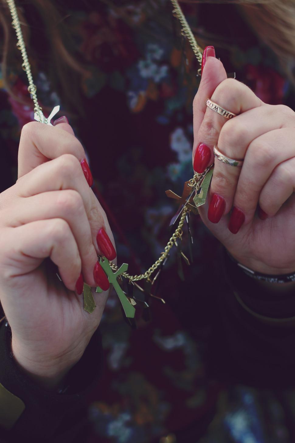 Free Image of Woman With Red Nails Holding Onto a Chain 