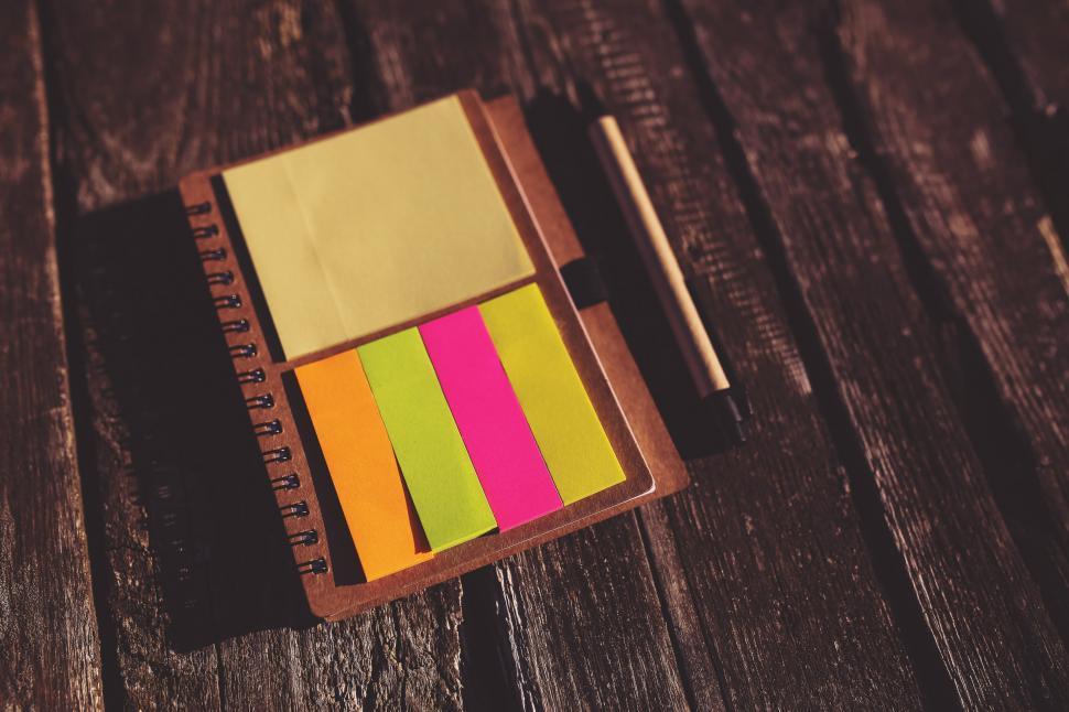 Free Image of Notebook With Sticky Notes and Pen on Wooden Table 