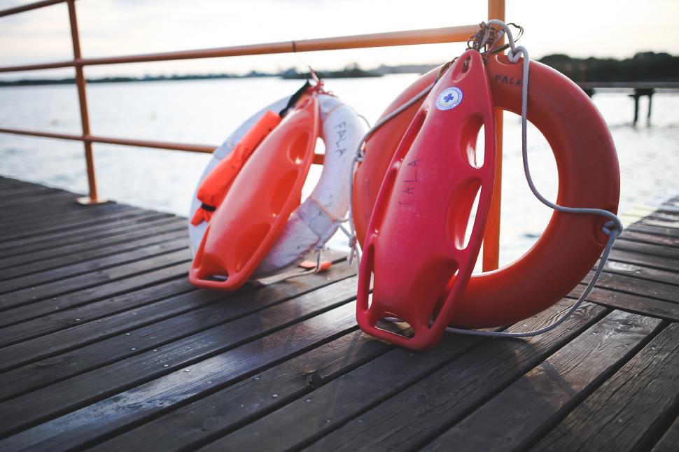 Free Image of Red and White Life Preservers on a Dock 