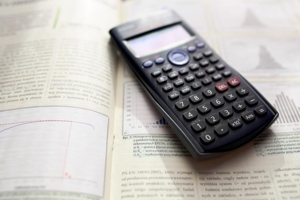 Free Image of Calculator on Top of an Open Book 