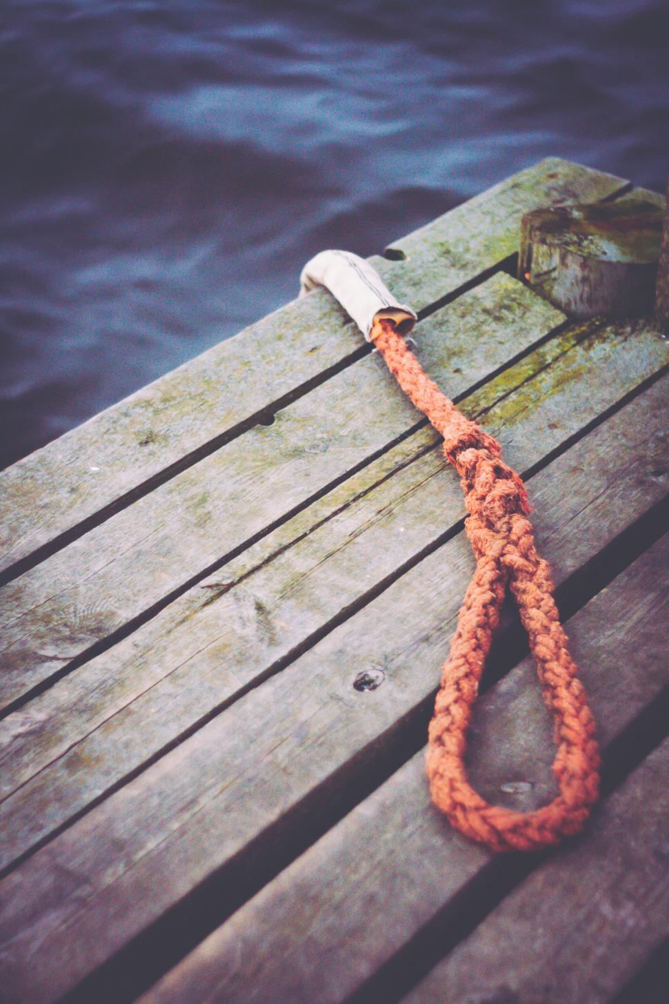 Free Image of Orange Rope Tied to Wooden Dock 