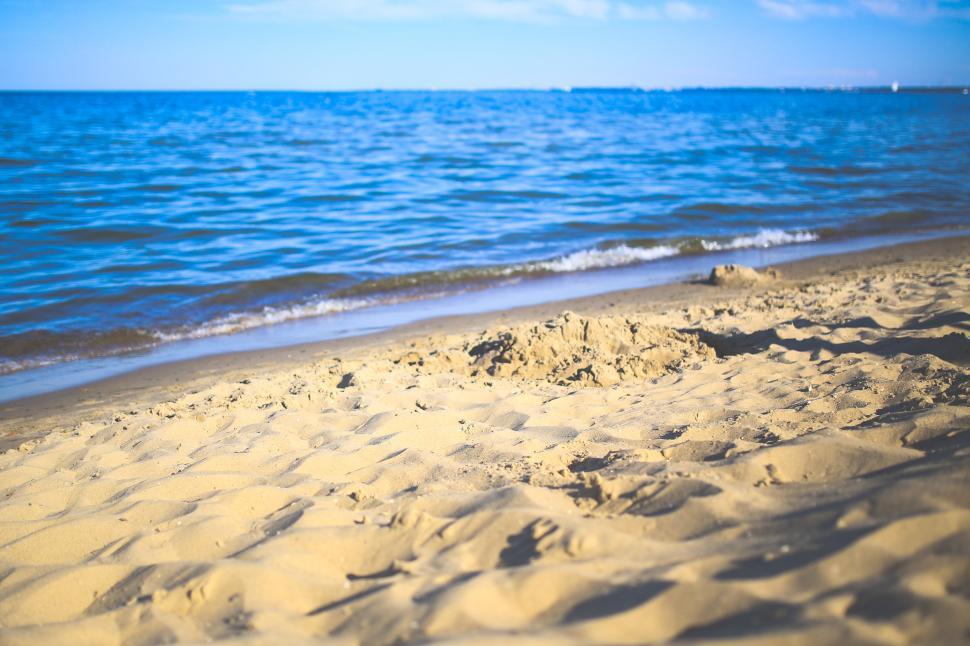 Free Image of Sandy Beach by the Ocean on a Blue Sky Day 