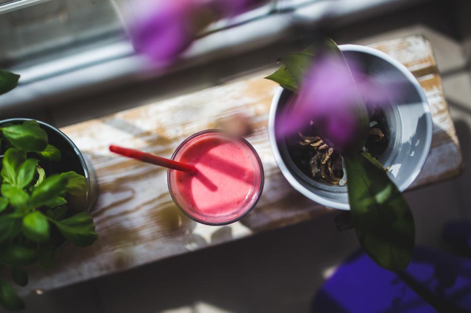 Free Image of Cup of Juice and Plant on Table 
