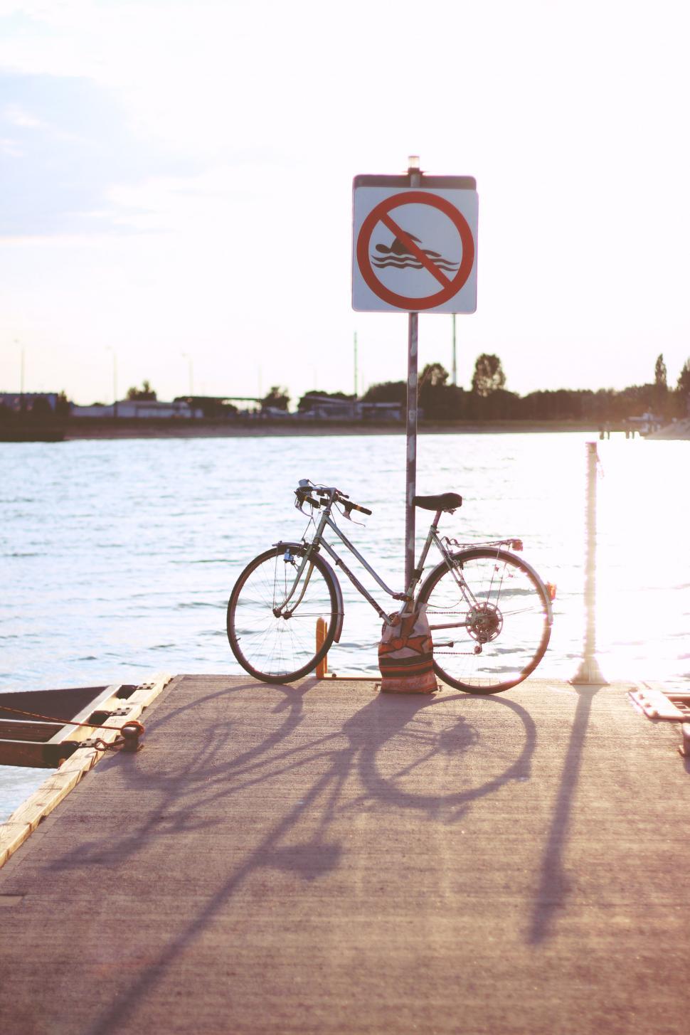 Free Image of Bicycle Parked on Dock Next to Sign 