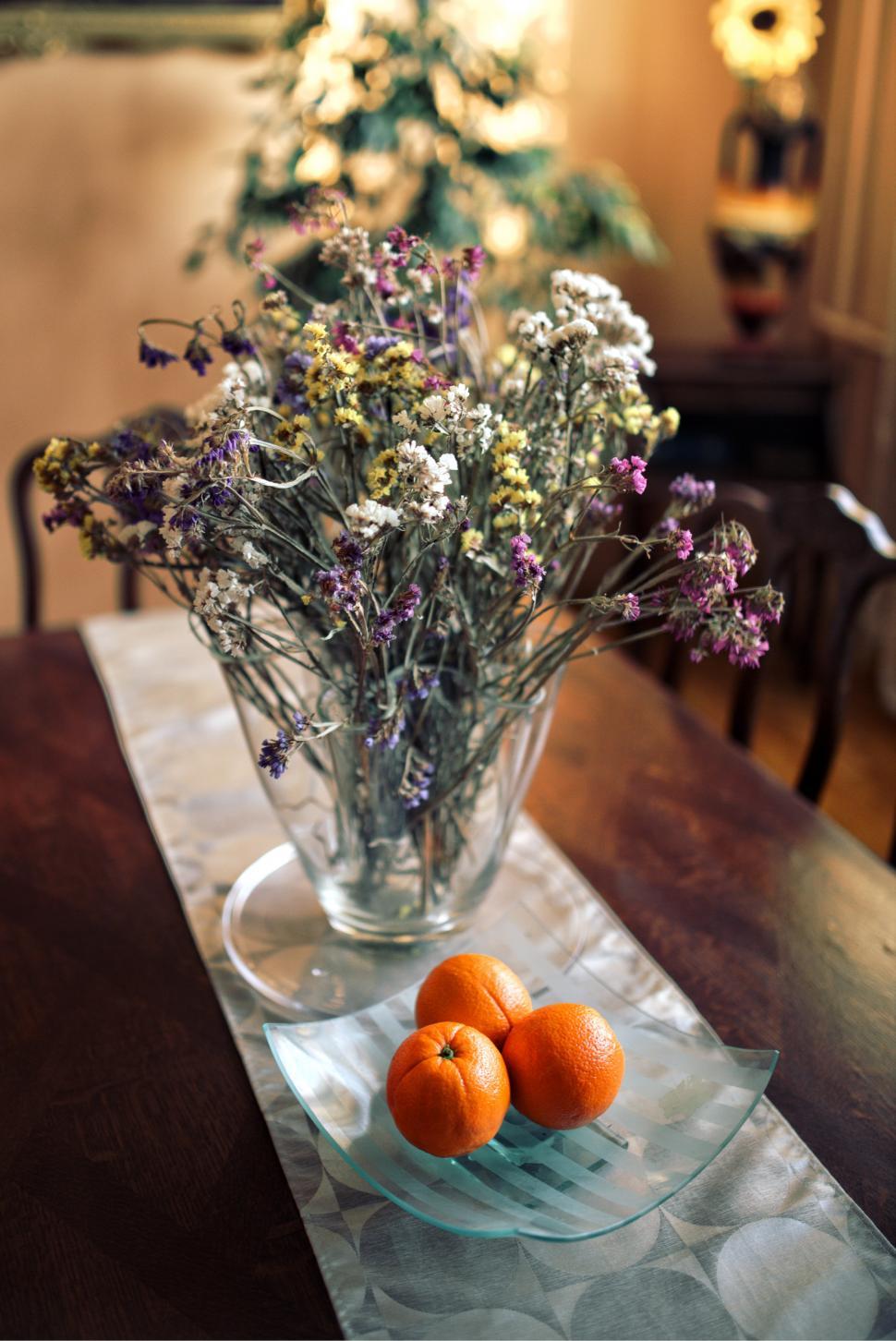 Free Image of Glass Vase Filled With Oranges on Table 