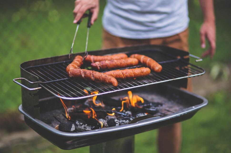 Free Image of Person Cooking Hot Dogs on a Grill 
