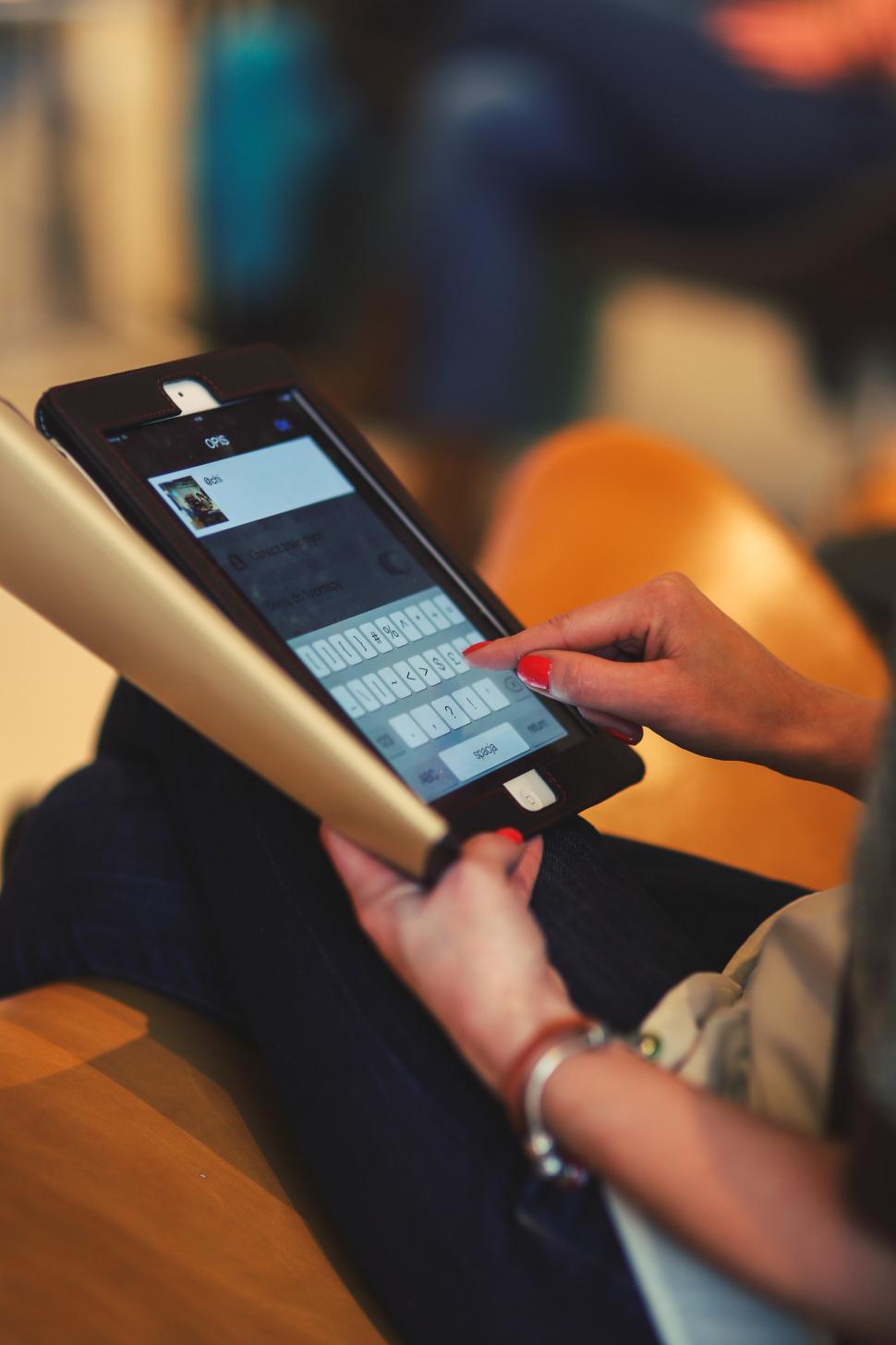 Free Image of Woman Sitting on Chair Using a Tablet 