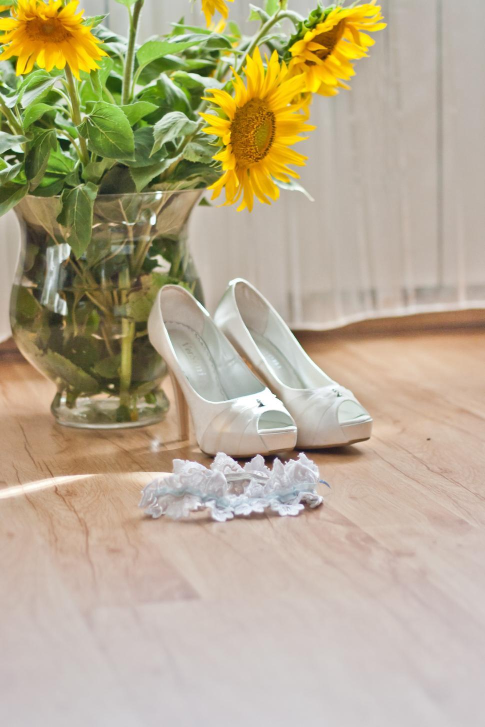 Free Image of Vase of Sunflowers and White Shoes 