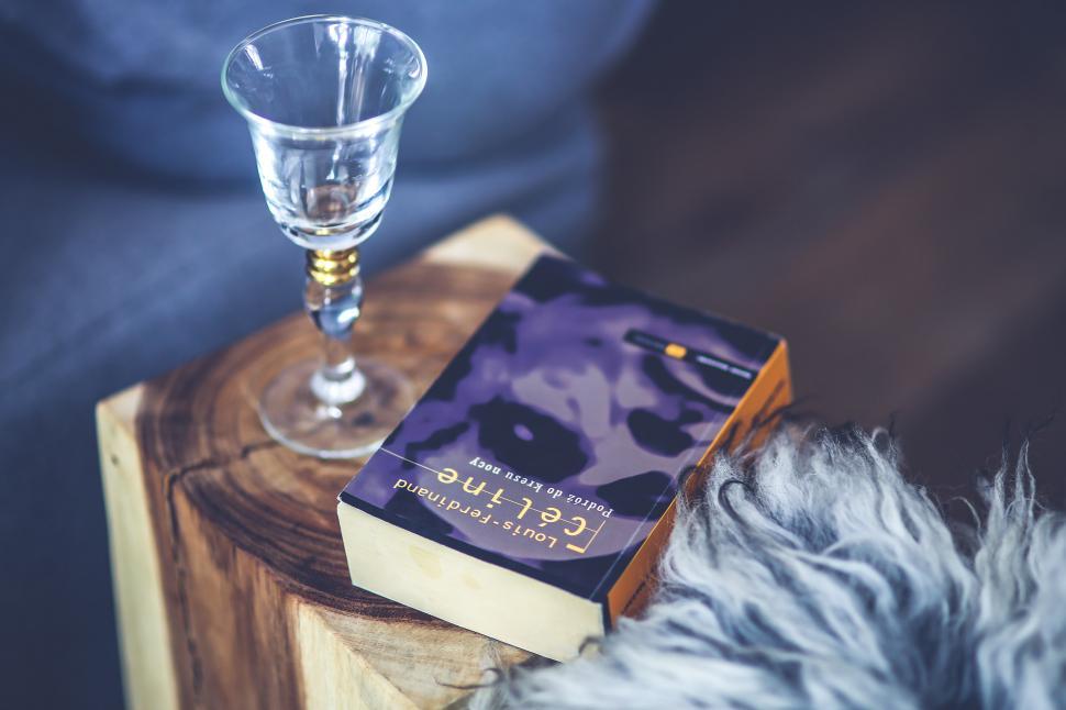 Free Image of A Glass of Wine and a Book on a Table 