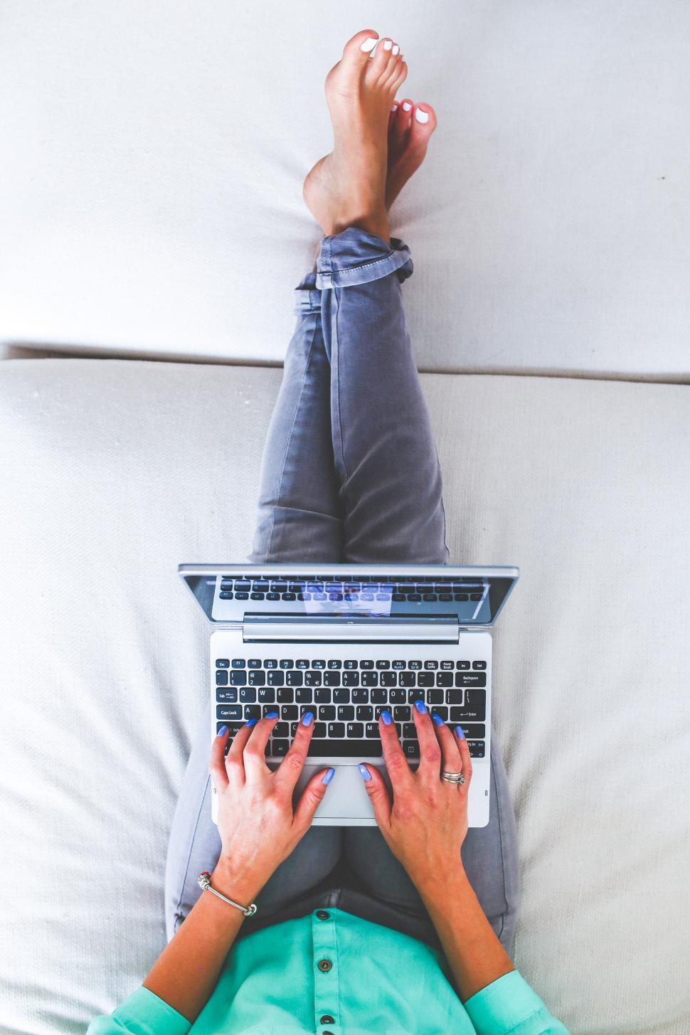 Free Image of Person Laying on Bed Using Laptop 